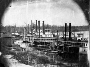 black and white photo of steamboats with smokestacks