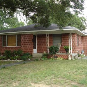 Single-story brick house and tree