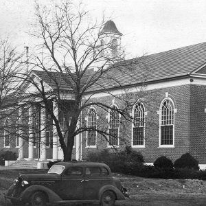 stately brick building with cupola arched windows and four columns