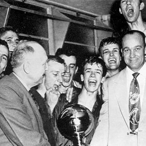 White men with trophy and young men behind them cheering