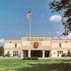 Two-story building with "Scimitar" logo and flag pole