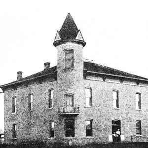 Two-story brick building and central tower with balcony