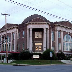 Two-story brick building with columns and arched windows on street corner