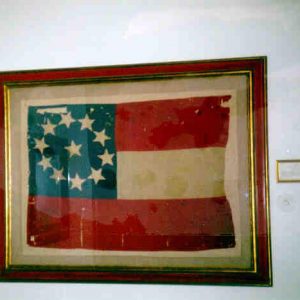 Framed red white and blue flag with star in center of circle of stars on blue field