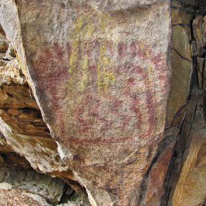 Faded red painting on rock wall