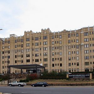 Lengthy multistory building with street and parked cars