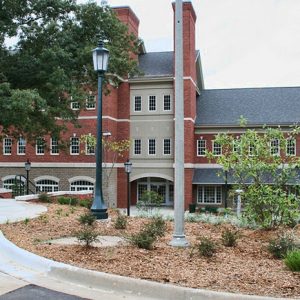 Three-story brick building with street lamp and trees