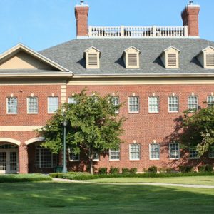 Two-story brick building with arched entrances and grounds