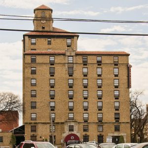 Side view of multistory hotel building with cupola and parking lot