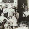 Group of white men and children outside store building