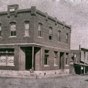 two story brick building on corner of street with other businesses