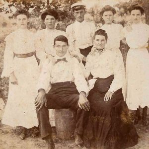 White man and woman sitting with four young white girls and white boy standing behind them