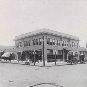 Two-story brick storefront on street corner and water tower