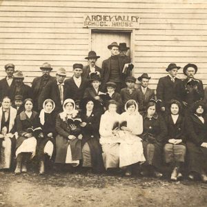 Group of white men and women outside "Archey Valley School House" building