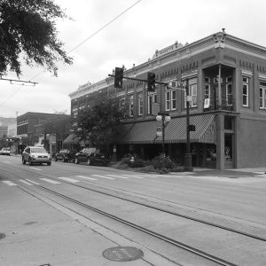 Multistory brick buildings on city street with traffic lights and trees