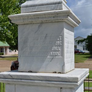 stone pedestal with raised text saying "When the last trumpet is sounded may each one answer the roll call of the heavenly army"