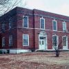 Two-story brick building with framed windows and doorways