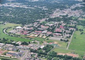 College campus buildings and grounds with town and countryside as seen from above