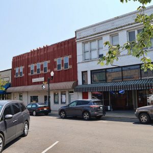 Multistory storefronts with parked cars on street