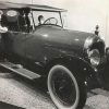 two people look inside an early twentieth century model car