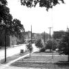 Street with brick buildings and city park with trees