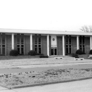 Brick building with columns and grounds with tall narrow windows