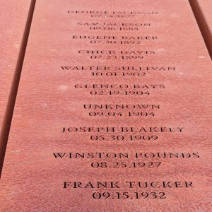 Rust-colored metal rectangle engraved with names and dates