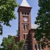 red brick building with clock tower and trees