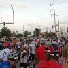 Crowd of people on bicycles with helmets on city street