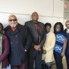 African-American men and women standing against wall smiling