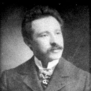 White man with mustache in suit and tie