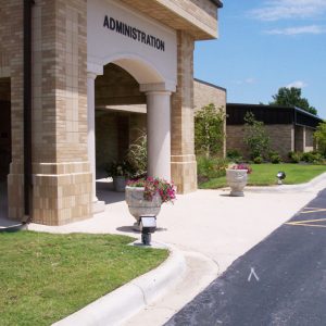 brick building entrance "Administration" with road running before it