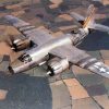 Twin engine airplane flying above rural landscape