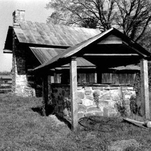 Covered brick well and log cabin with brick chimney