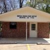 Small brick building with sign saying "United States Post Office Beirne, AR 71721" and parking lot