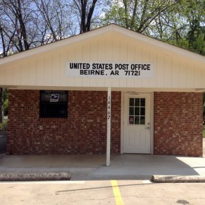 Small brick building with sign saying "United States Post Office Beirne, AR 71721" and parking lot