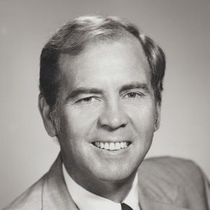 White man smiling in suit and tie