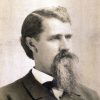 White man with long beard in suit and tie