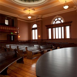 Interior of synagogue with wooden pews and glass dome roof