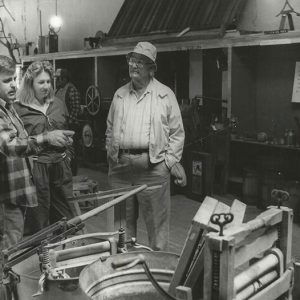 White man woman and older white man standing in machinery exhibit in museum