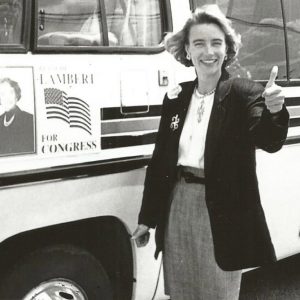 White woman giving the "thumbs-up" by campaign bus