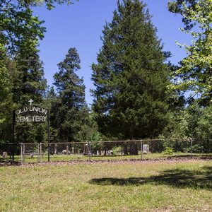 Fenced-in cemetery with "Old Union Cemetery" on iron arch gate