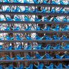 Hand-blown glass bluebird display on thin shelves outdoors with forest and mountains in background