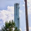 Cylindrical "Bluff City" water tower with trees at its base