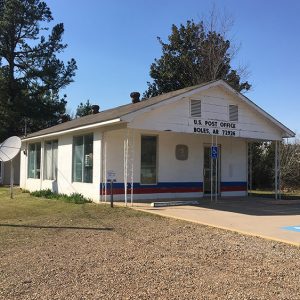 Single-story building with covered porch on concrete parking lot