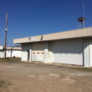 Two two-car garage buildings with radio tower behind them