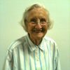 Older white woman with glasses smiling in striped shirt