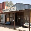 Storefront and cafe building with couches on dirt road