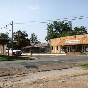 four way intersection with stop signs and a gazebo opposite a store