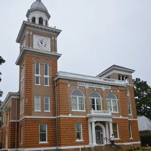 Multistory brick building with arched windows and clock tower